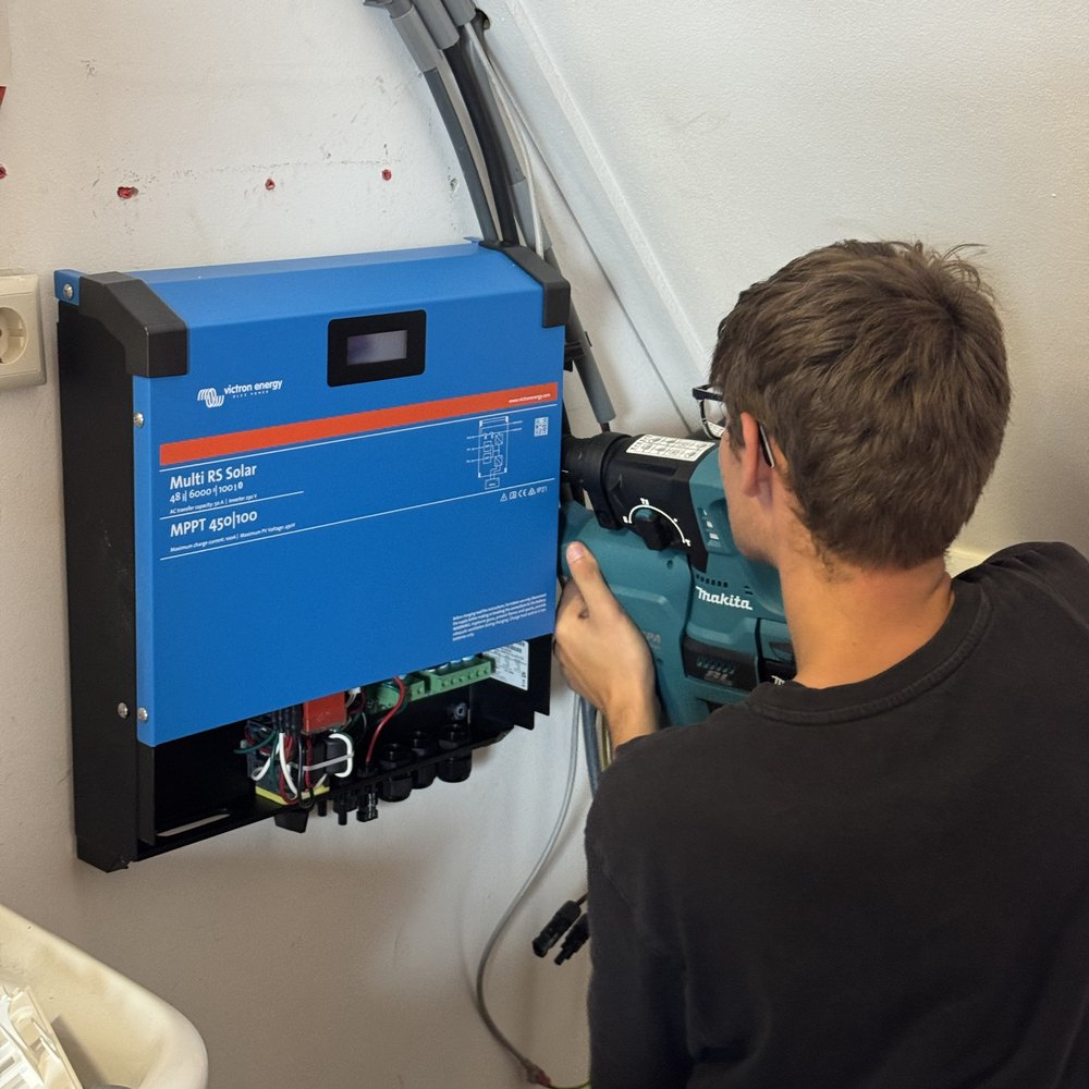 Gert-Jan monteert een Victron Multi RS Solar aan de wand