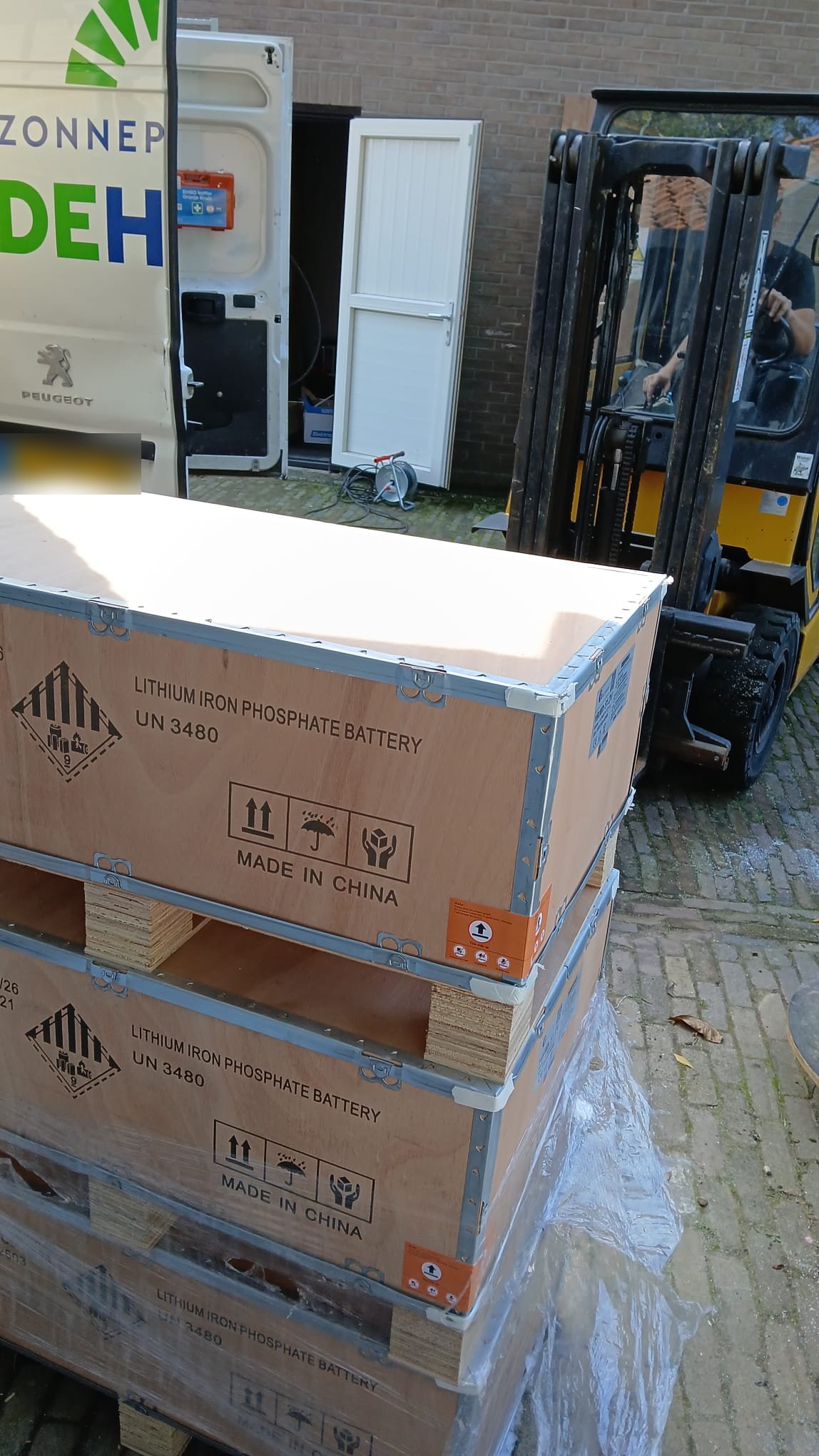Pallets met lithium-ijzerfosfaat batterijen worden met een heftruck gelost bij de werkplaats